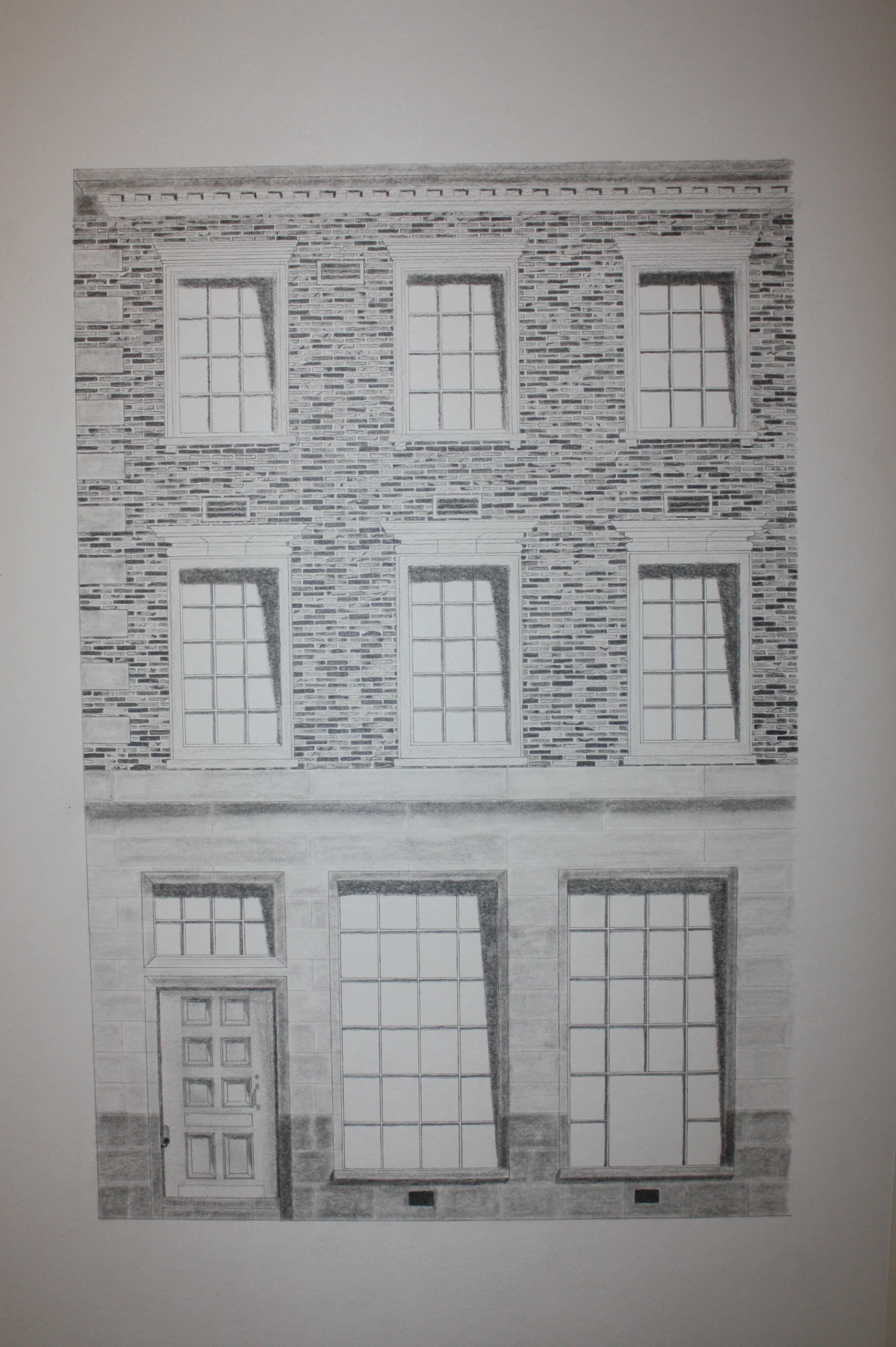 Hand-drawn 1:10 elevation of a brick facade with two storeys of tall multi-paned windows above a stone-base ground floor, rendered in pen and ink