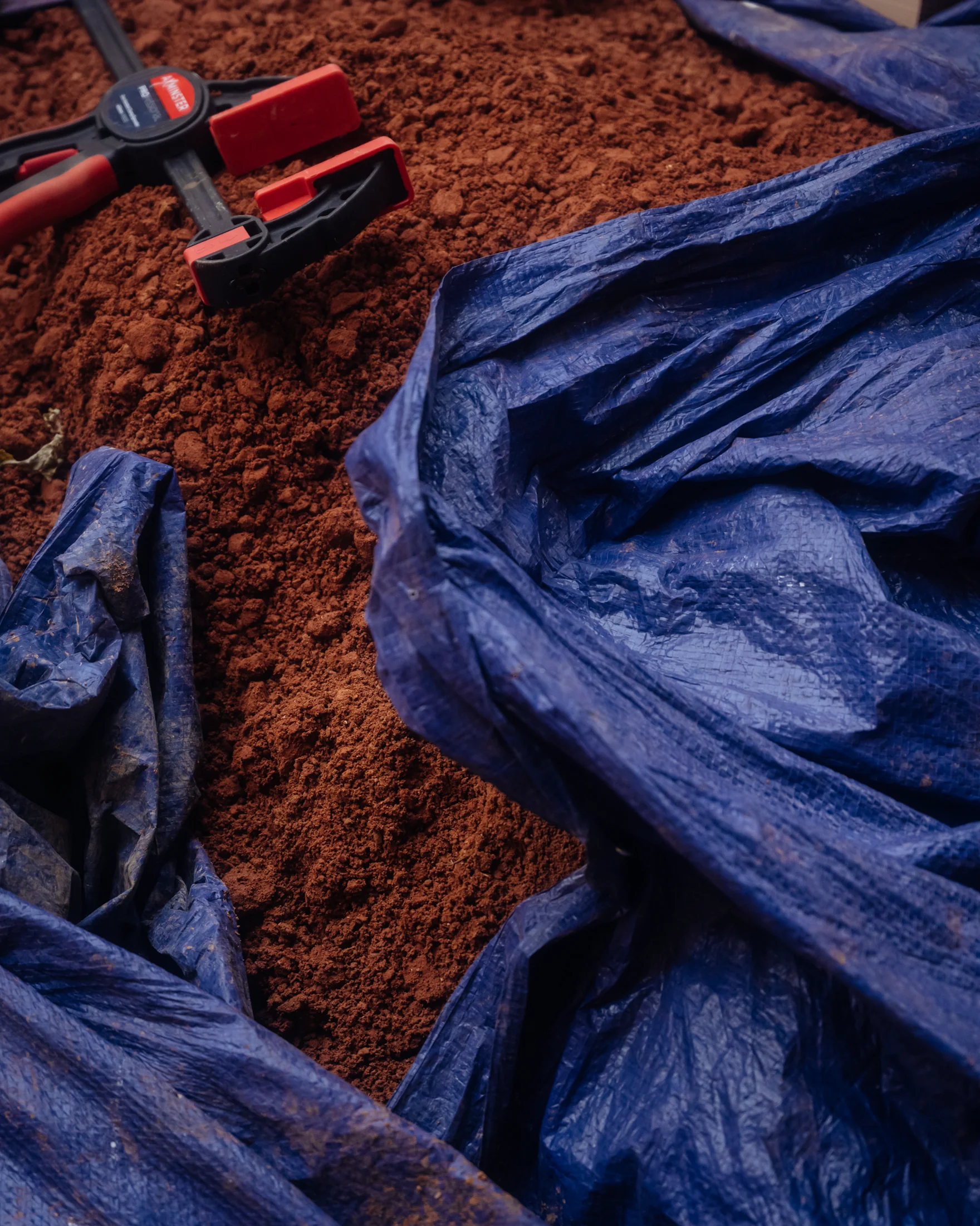 Tarpaulin pulled back to reveal hand-processed London clay ready to ram