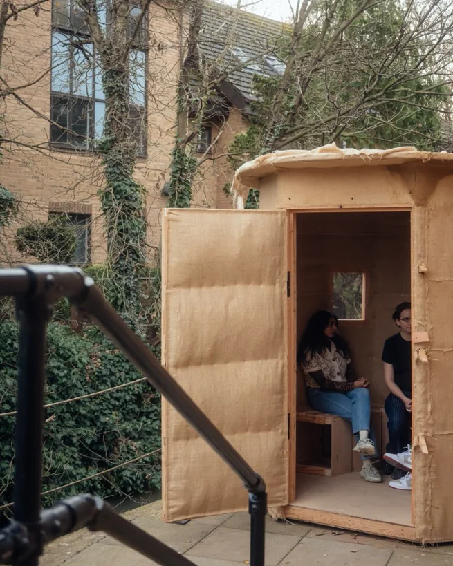 The finished canvas-wrapped sauna with two people sitting inside