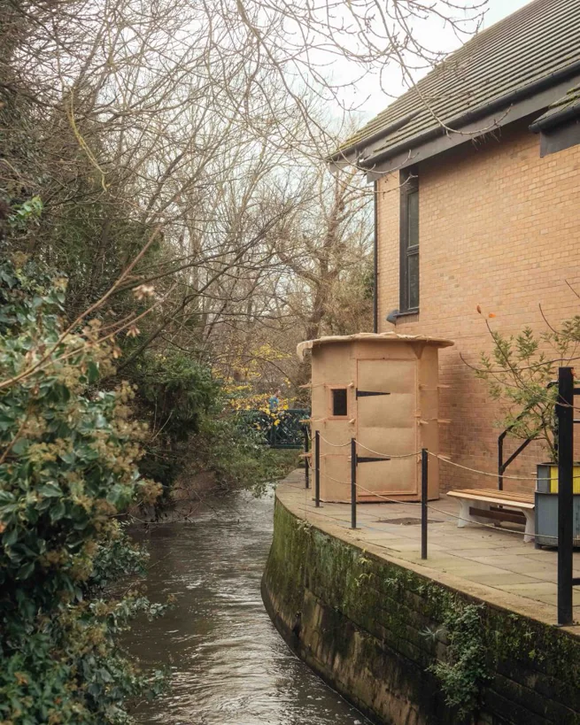 The sauna sited on a stone terrace beside a small stream on the Kingston School of Art campus