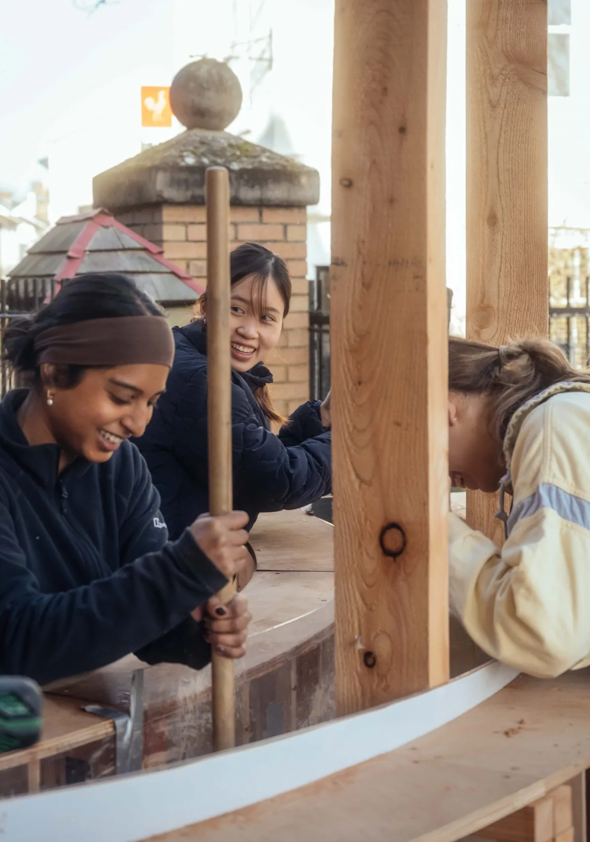 Students constructing a timber and rammed-earth pavilion during a live build