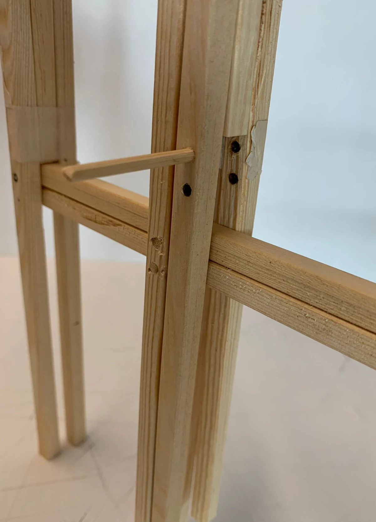 Close-up of a timber corner joint, showing how the vertical post, horizontal beams and cross-bracing meet at a single node