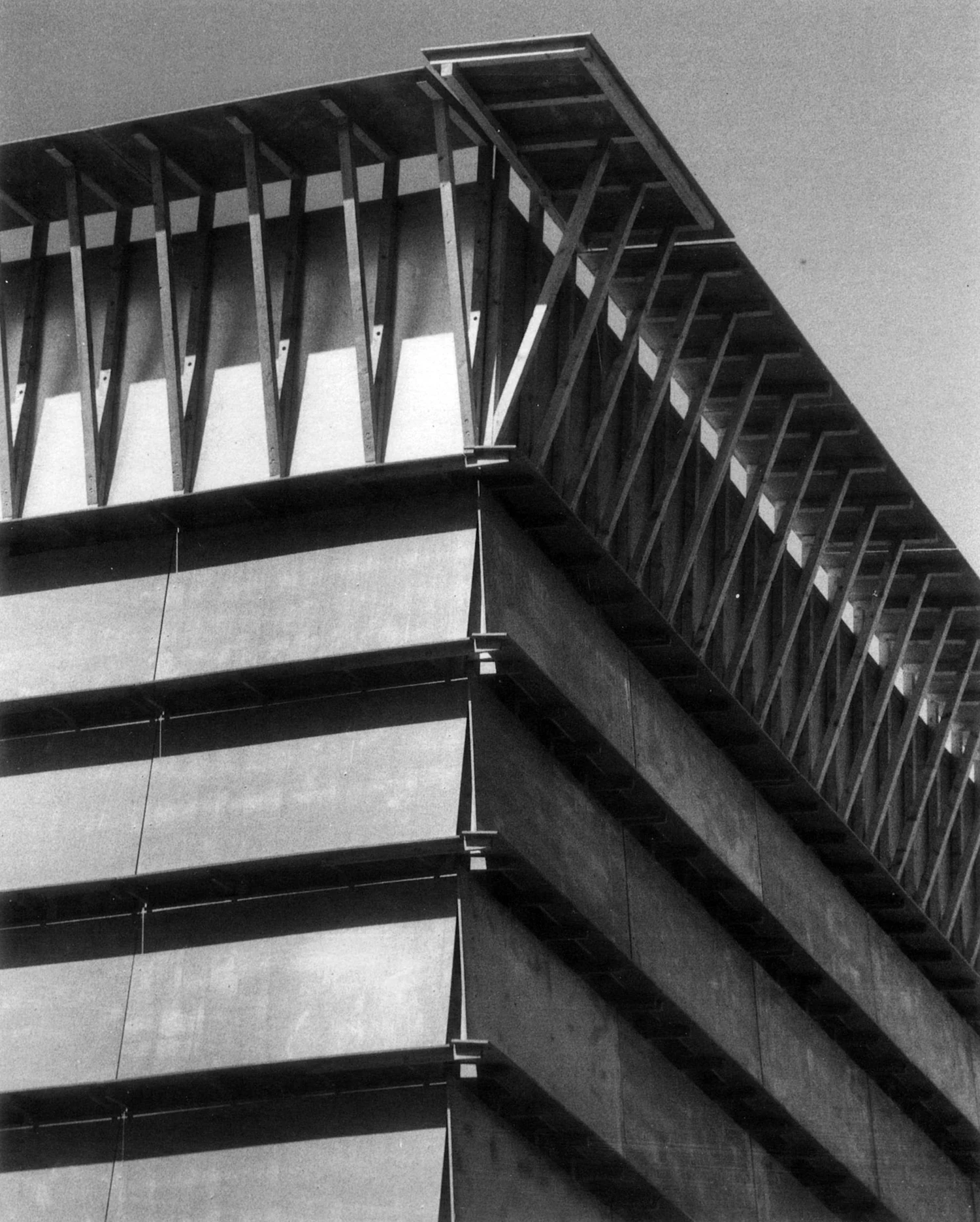 Black-and-white photograph of Herzog and de Meuron's Ricola warehouse, showing the layered concrete panel facade with vertical fins