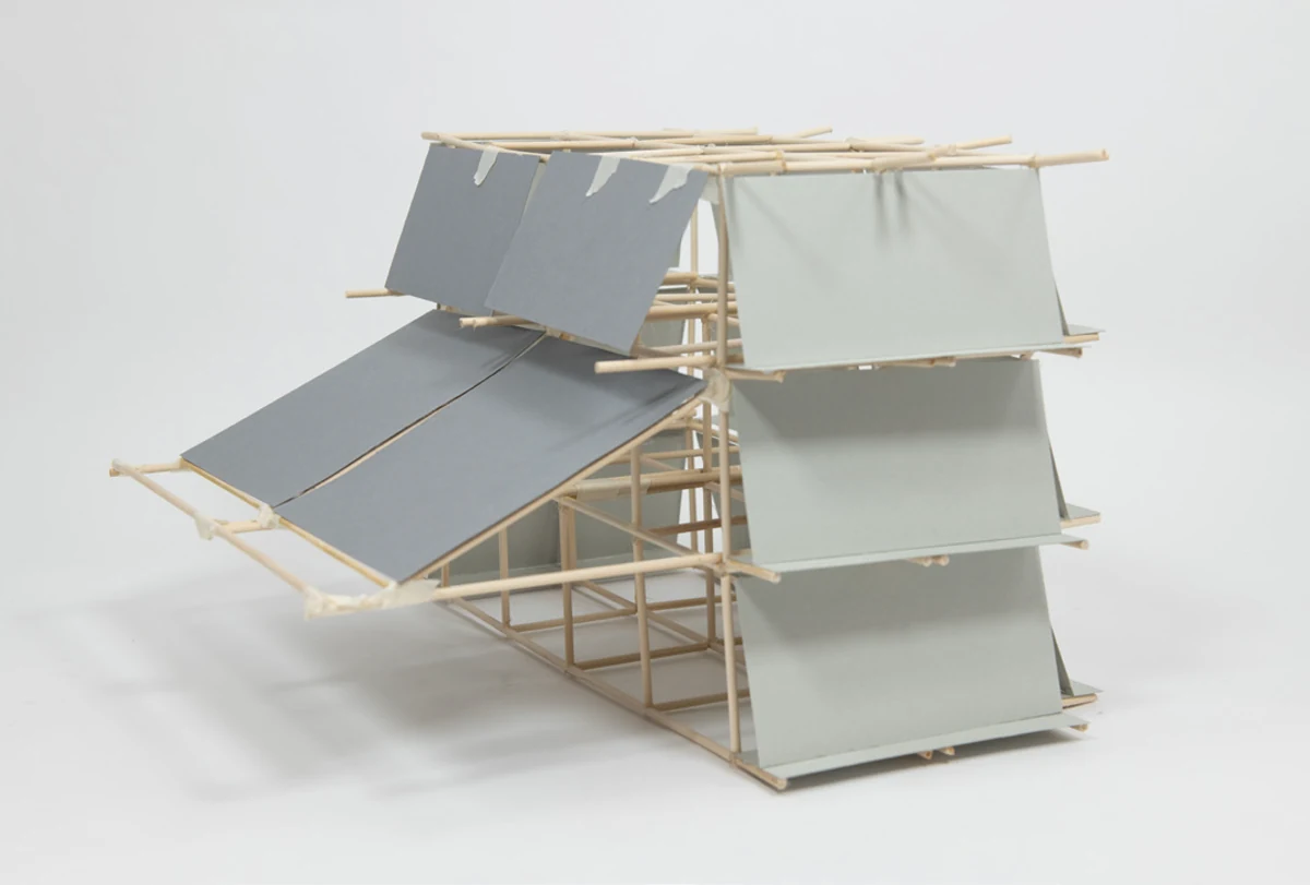 Card sketch model of a section of the tower, showing four levels of grey panels resting on top of extended horizontal beams