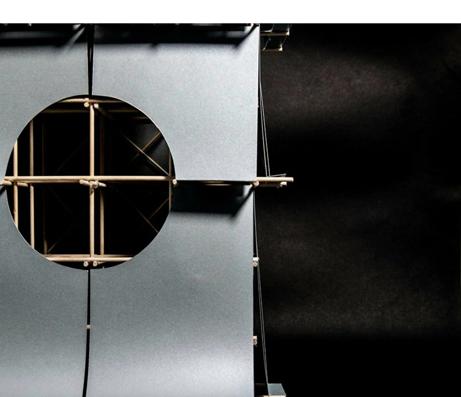 Close-up detail of the model's circular window, framed by the curving metallic panels of the skin set against a dark void