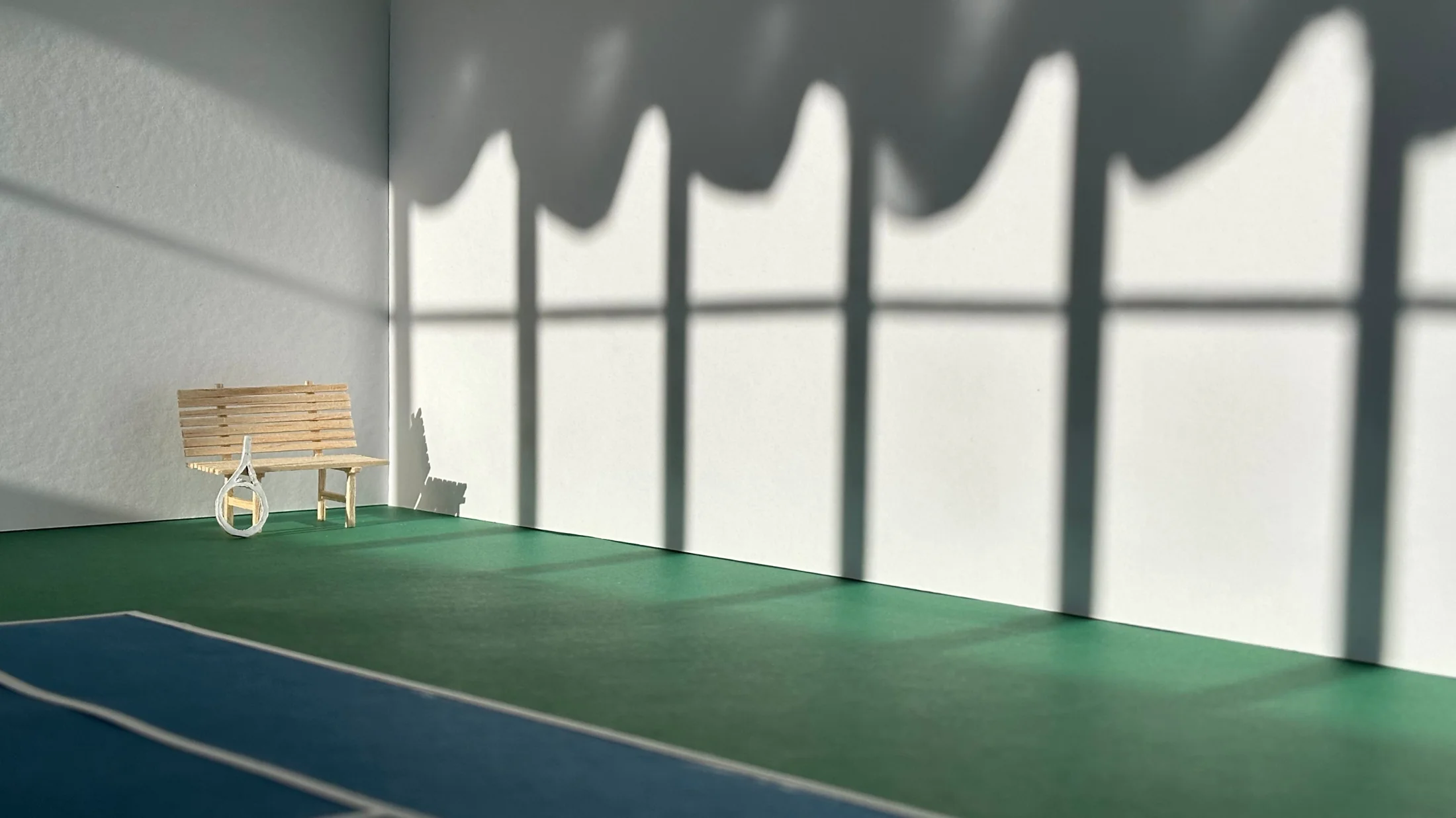 Wide view of the sports court with louvre shadows cast across the inner wall and the wavy white ceiling above